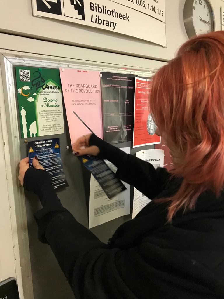 Student pinning the leaflet to a pin board