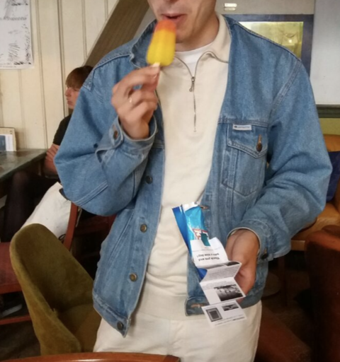 someone eating an ice cream while holding the brochure 