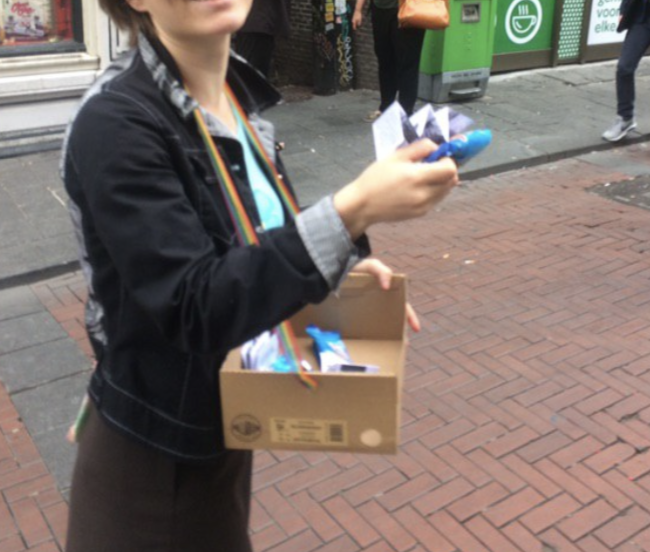 a student giving away an ice cream and a brochure 